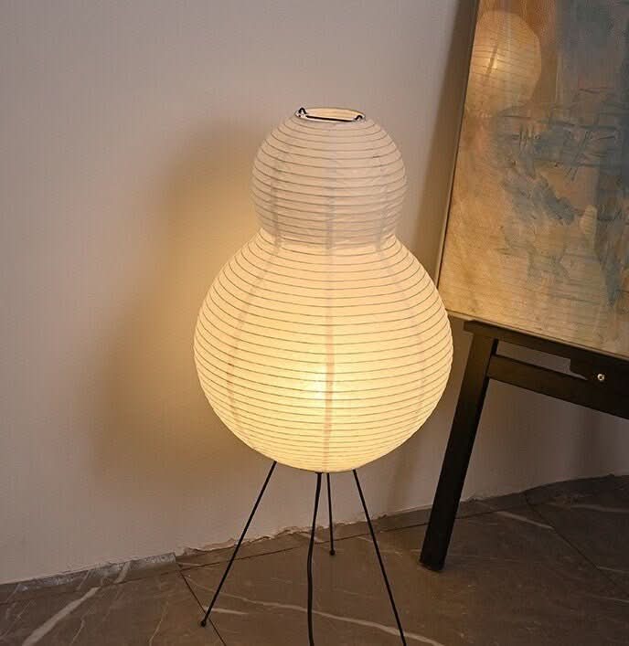White paper floor lamp with pear shape on thin black legs, home decor